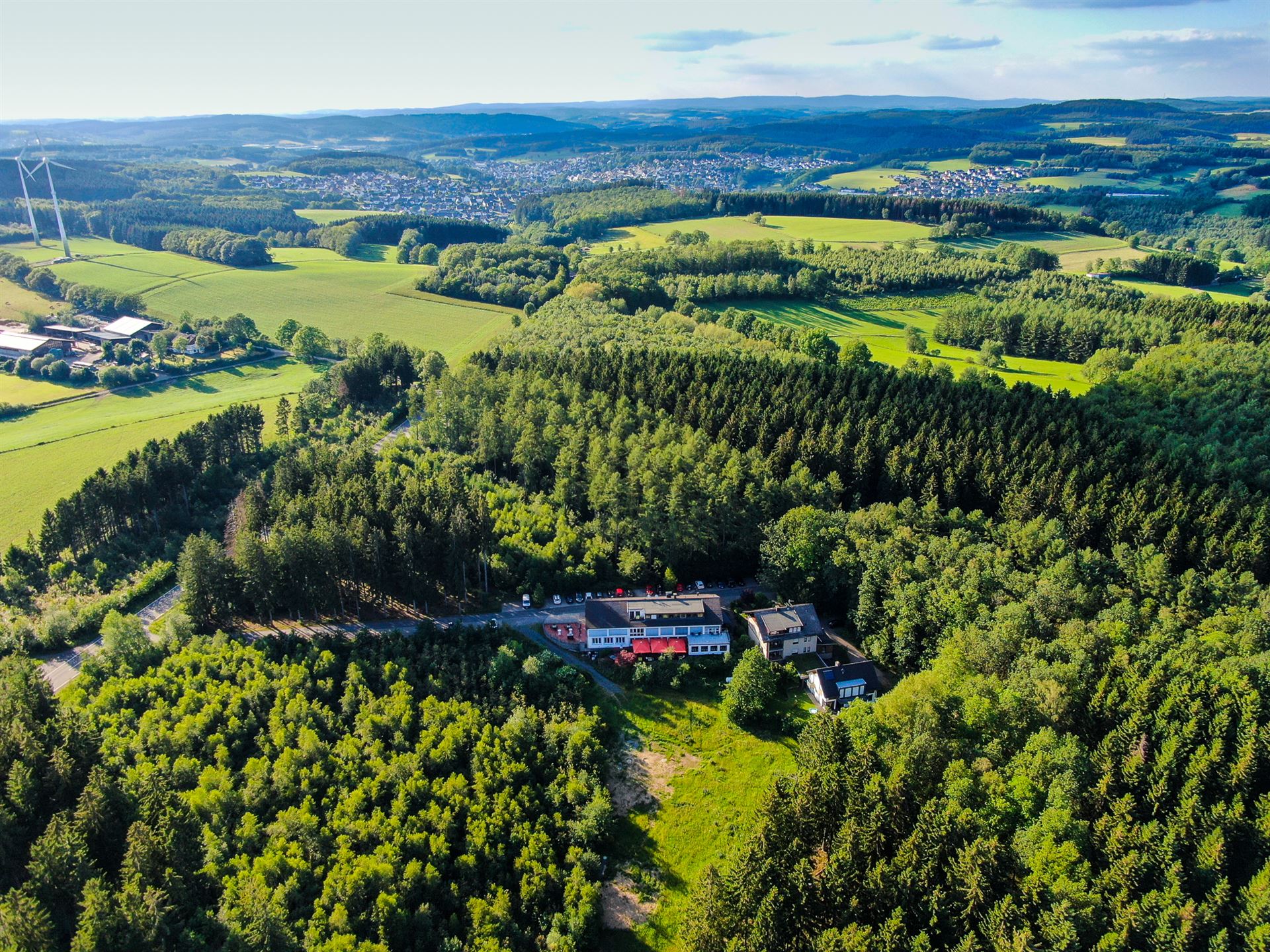 Das Luftbild zeigt die herrliche Landschaft des Sauerlands und in der Mitte das Hotel